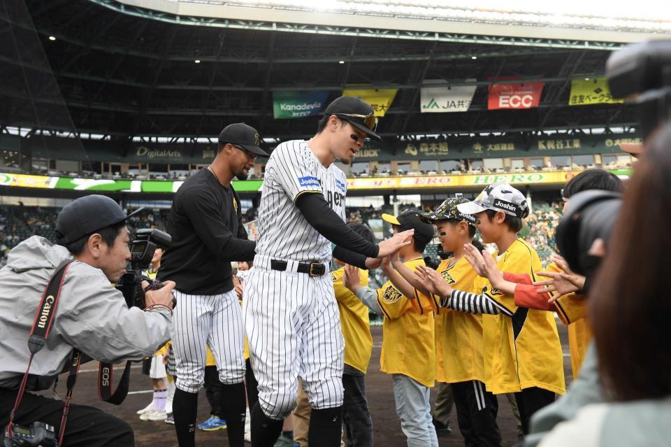 　こどもたちとタッチを交わすデュプランティエ（左）と佐藤輝（撮影・西田忠信）