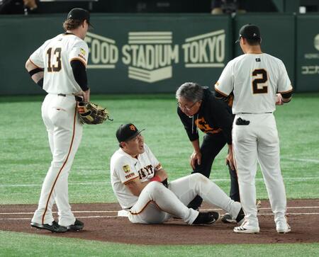 　１回、犠打の中野と送球を受けた際に交錯し左腕を痛めた岡本（撮影・金田祐二）