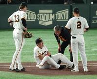 　１回、犠打の中野と送球を受けた際に交錯し左腕を痛めた岡本（撮影・金田祐二）