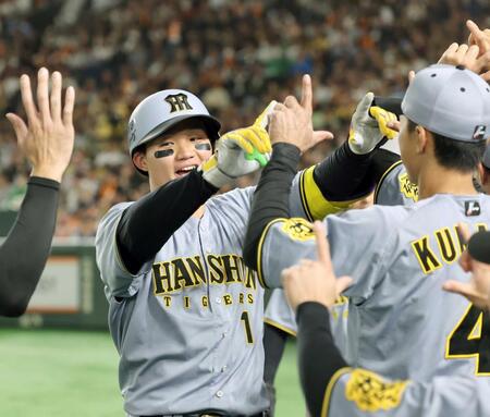 　２回、２ランを放ちナインの出迎えに笑顔を見せる森下（左）＝撮影・田中太一