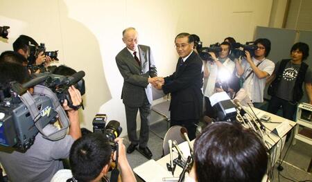 　会見後ガッチリ握手する阪急ＨＤ・角和夫社長（左）と阪神電鉄・坂井信也常務取締役＝２００６年６月