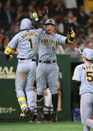 ５回、２ランを放った森下（左）とタッチを交わす佐藤輝（撮影・堀内翔）