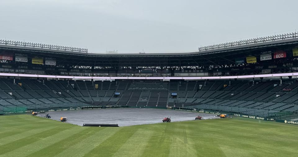 　雨が降り、シートがかけられる甲子園