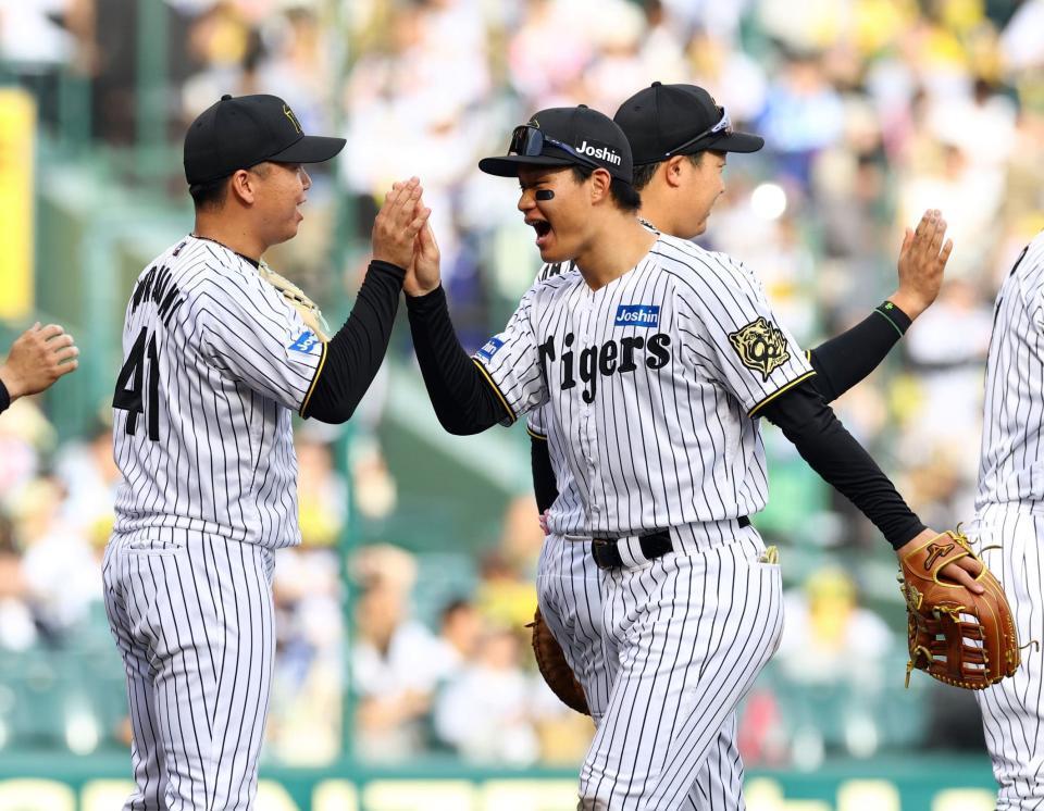 　完封勝利を飾った村上（左）とタッチする森下（撮影・山口登）