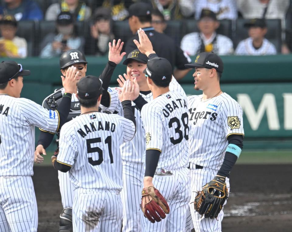 　２試合連続完封に笑顔でハイタッチをかわす村上ら阪神ナイン（撮影・飯室逸平）