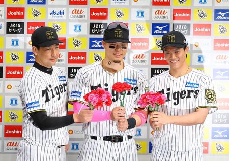 　お立ち台でカーネーションを手に写真に納まる（左から）岩崎、佐藤輝、湯浅（撮影・山口登）