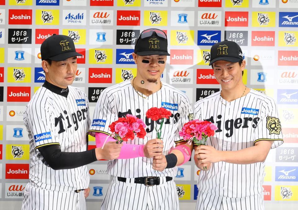 　お立ち台でカーネーションを手に写真に納まる（左から）岩崎、佐藤輝、湯浅（撮影・山口登）