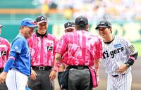 　試合前、井上監督とメンバー表を交換した藤川監督は審判団と笑顔で握手をする（撮影・山口登）