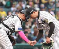 　９回、最後を締めた岩崎は坂本（左）と握手を交わす（撮影・北村雅宏）
