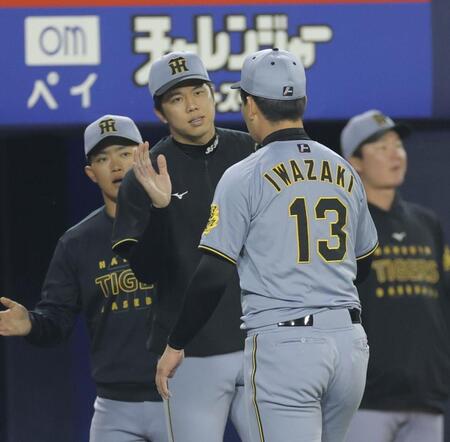 　１１回を無失点に抑えた岩崎を迎える才木（撮影・西岡正）