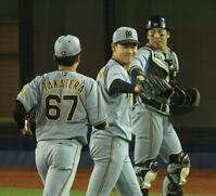 １０回、ピンチを脱し阪神・高寺（６７）と笑顔でタッチする及川（中央）＝撮影・金田祐二