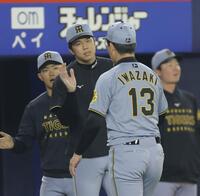 　１１回を無失点に抑えた岩崎を迎える才木（撮影・西岡正）