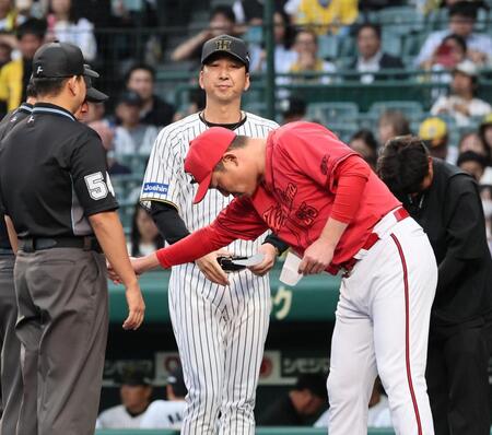 　メンバー表の確認で、藤川監督（奥）と視線を合わせることなく、審判と握手をする新井監督（撮影・田中太一）