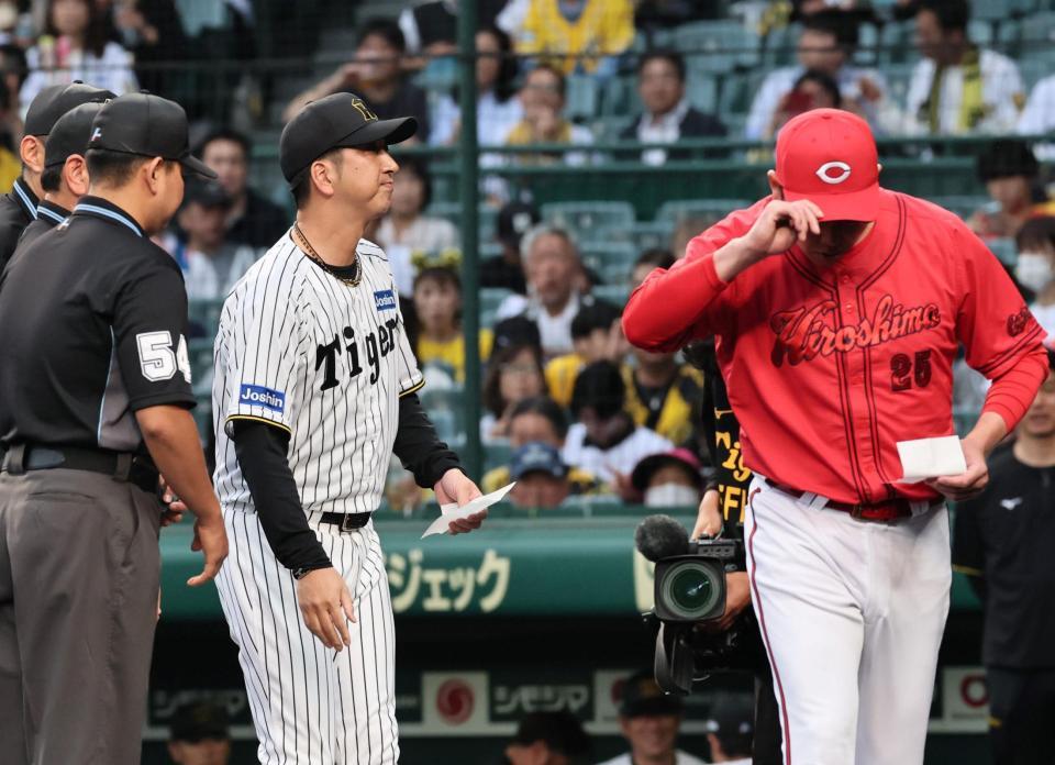 　メンバー表の確認で、藤川監督（左）と視線を合わせることなくベンチへ戻る新井監督（撮影・田中太一）