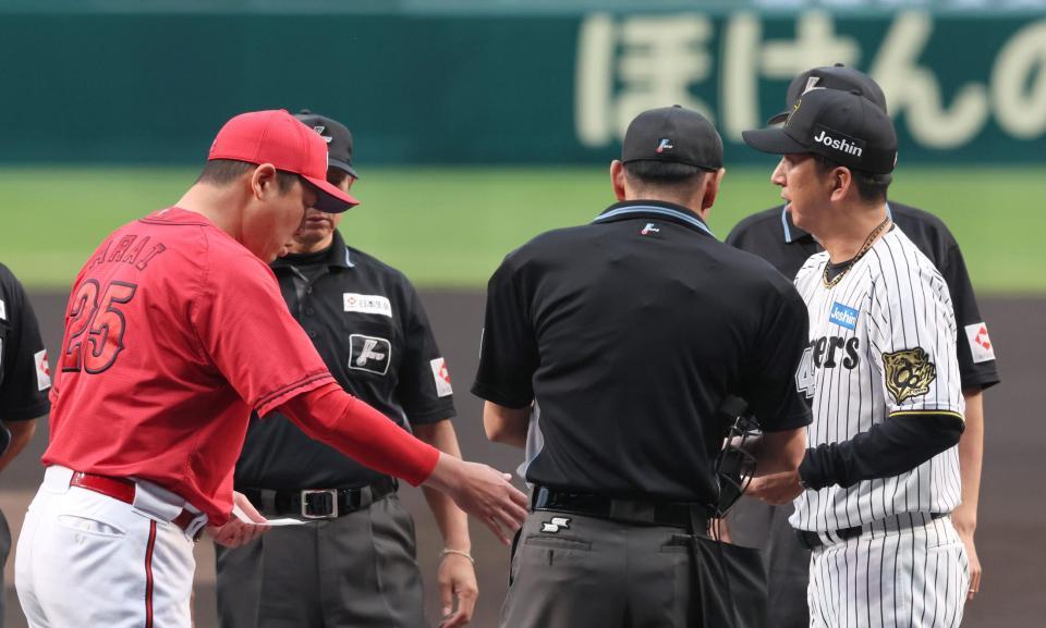 　メンバー表交換し、握手を交わす藤川監督（右）と新井監督（撮影・北村雅宏）