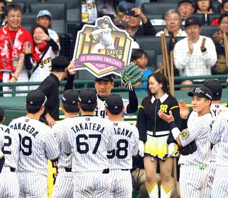 　１００セーブを達成した岩崎はボードを掲げる（撮影・山口登）