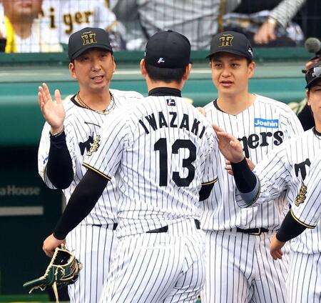 　岩崎を迎える藤川監督（左）と大竹（右）＝撮影・山口登