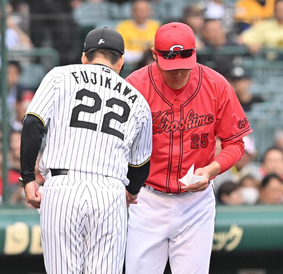 　藤川監督（２２）とメンバー表の交換をする新井監督（撮影・西田忠信）