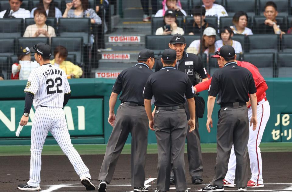 　新井監督とメンバー表を交換し、足早にベンチに戻る藤川監督（左）＝撮影・山口登