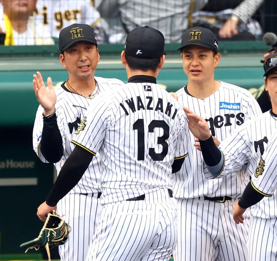 　岩崎を迎える藤川監督（左）と大竹（右）＝撮影・山口登