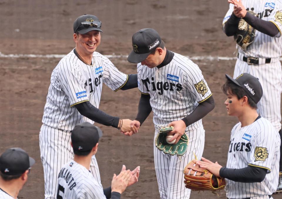 　１００セーブを挙げた岩崎（中央右）を祝福する藤川監督（撮影・立川洋一郎）