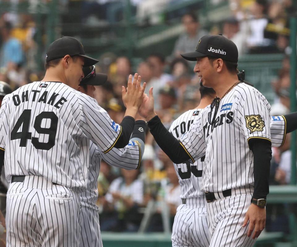 　今季初勝利を挙げた大竹とタッチを交わす藤川監督（右）＝撮影・北村雅宏