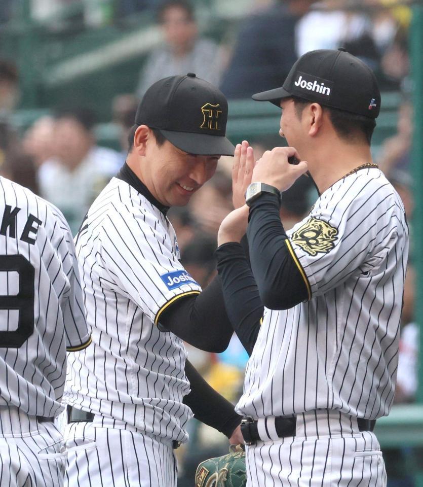 　最後を締めた岩崎は藤川監督（右）とタッチを交わす（撮影・北村雅宏）