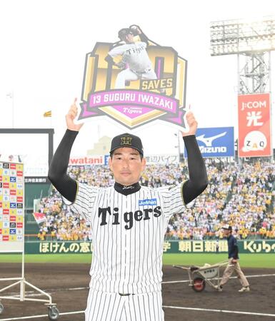 　通算１００セーブ達成の記念ボードを掲げる岩崎（撮影・西田忠信）