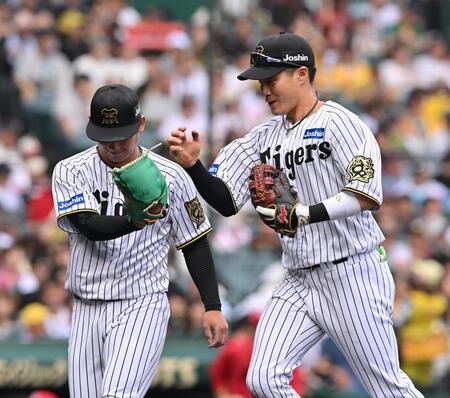 　２回、モンテロの打球で好守備を見せた木浪（右）とタッチを交わす伊原（撮影・西田忠信）