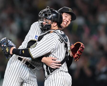 　完封勝利を挙げた才木は好リードの梅野と抱き合って喜ぶ（撮影・田中太一）