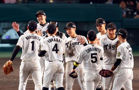 　完封勝利を飾った才木（左から２人目）は森下らナインと笑顔でタッチする（撮影・山口登）
