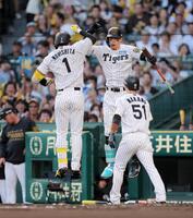 　　１回、先制２ランを放った森下（左）とタッチを交わす佐藤輝