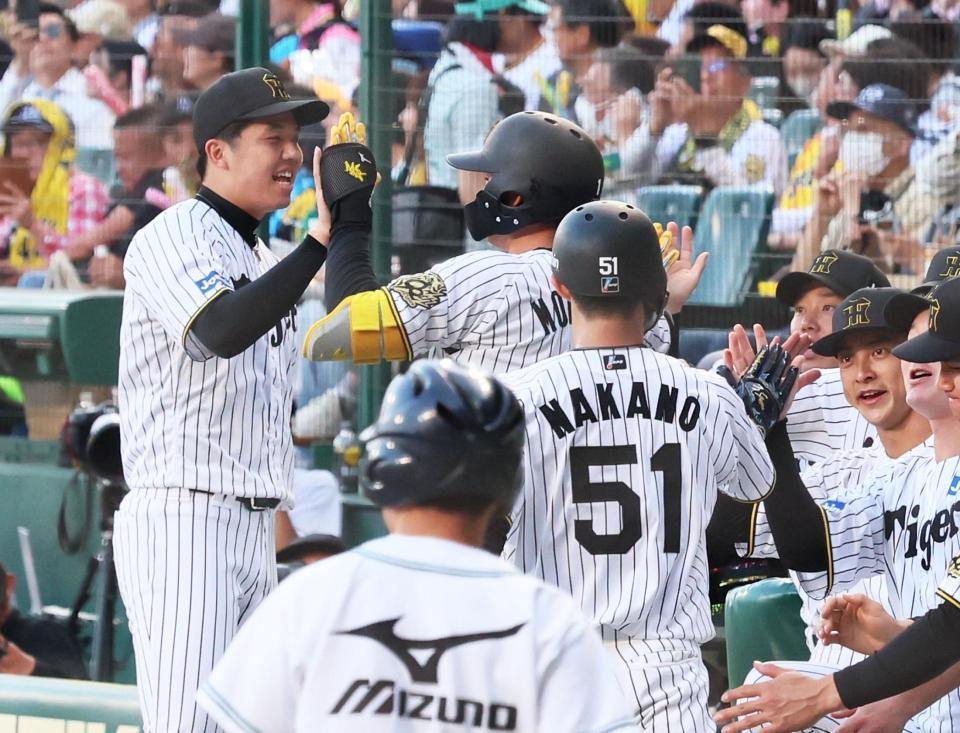 　１回、先制２ランを放った森下を迎えてタッチを交わす才木（左端）＝撮影・立川洋一郎