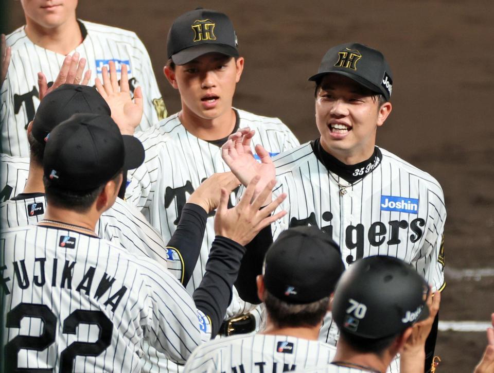 　今季初完封勝利を挙げ、出迎える藤川監督（２２）とタッチを交わす才木（撮影・立川洋一郎）