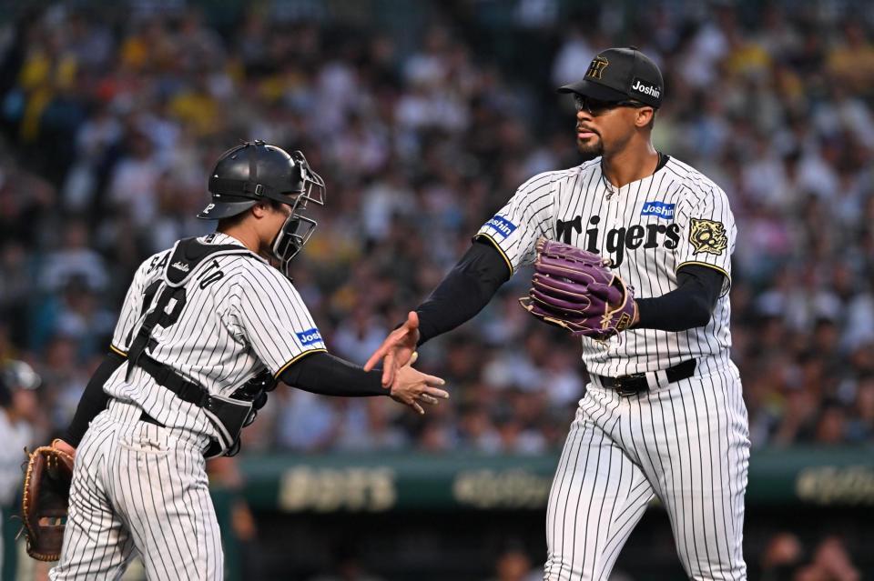 　３回、中山を三振に仕留め、坂本（左）とタッチを交わすデュプランティエ（撮影・西田忠信）