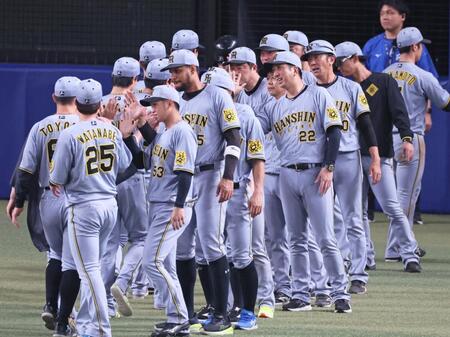 　延長戦を制し勝利のタッチを交わす藤川監督（２２）ら阪神ナイン（撮影・立川洋一郎）