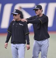 　植田の肩を揉む森下（撮影・田中太一）