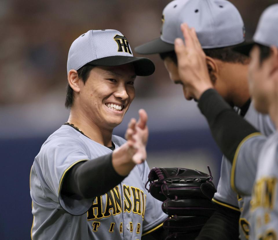 　１０回、中日打線を無失点に抑えナインとタッチを交わす湯浅（撮影・田中太一）