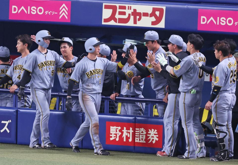 　１１回、森下の適時二塁打で生還し、ナインとタッチを交わす（手前左から）中野、近本（撮影・立川洋一郎）