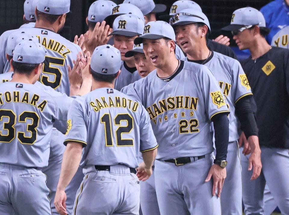 　延長戦を制し勝利のタッチを交わす藤川監督（２２）ら阪神ナイン（撮影・立川洋一郎）