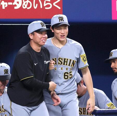 　久しぶりに勝利投手となり、村上と競うようにベンチを出る湯浅（右）＝撮影・北村雅宏