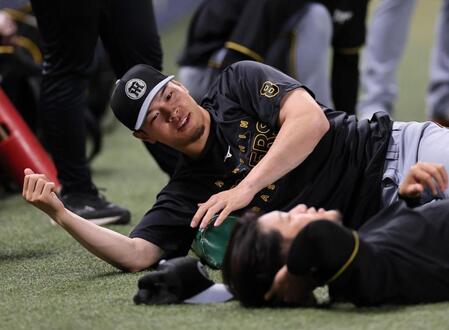 　ストレッチをする佐藤輝（撮影・田中太一）