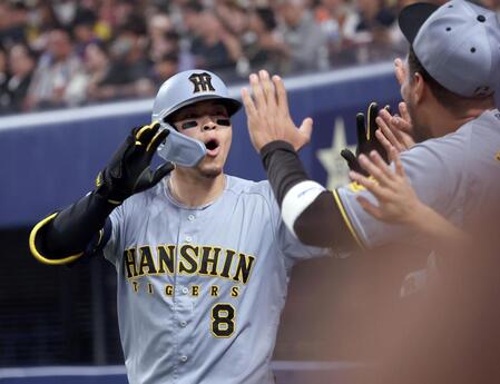 　２回、ソロを放ちナインとタッチを交わす佐藤輝（撮影・田中太一）