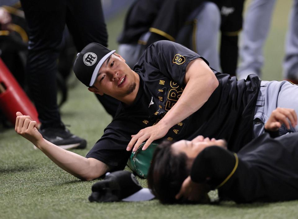 　ストレッチをする佐藤輝（撮影・田中太一）