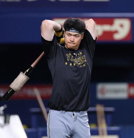 　バットで体をほぐす佐藤輝（撮影・北村雅宏）