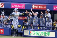 　２回、同点ソロを放ちナインの出迎えを受ける佐藤輝（撮影・立川洋一郎）