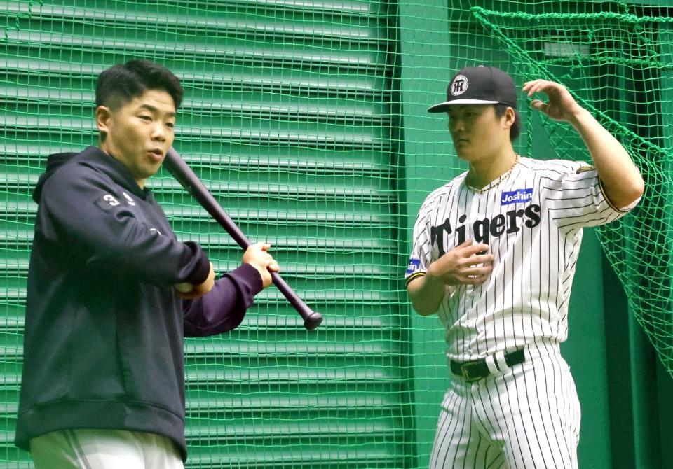 　ソフトバンク・近藤健介（左）からアドバイスを受ける前川（撮影・山口登）