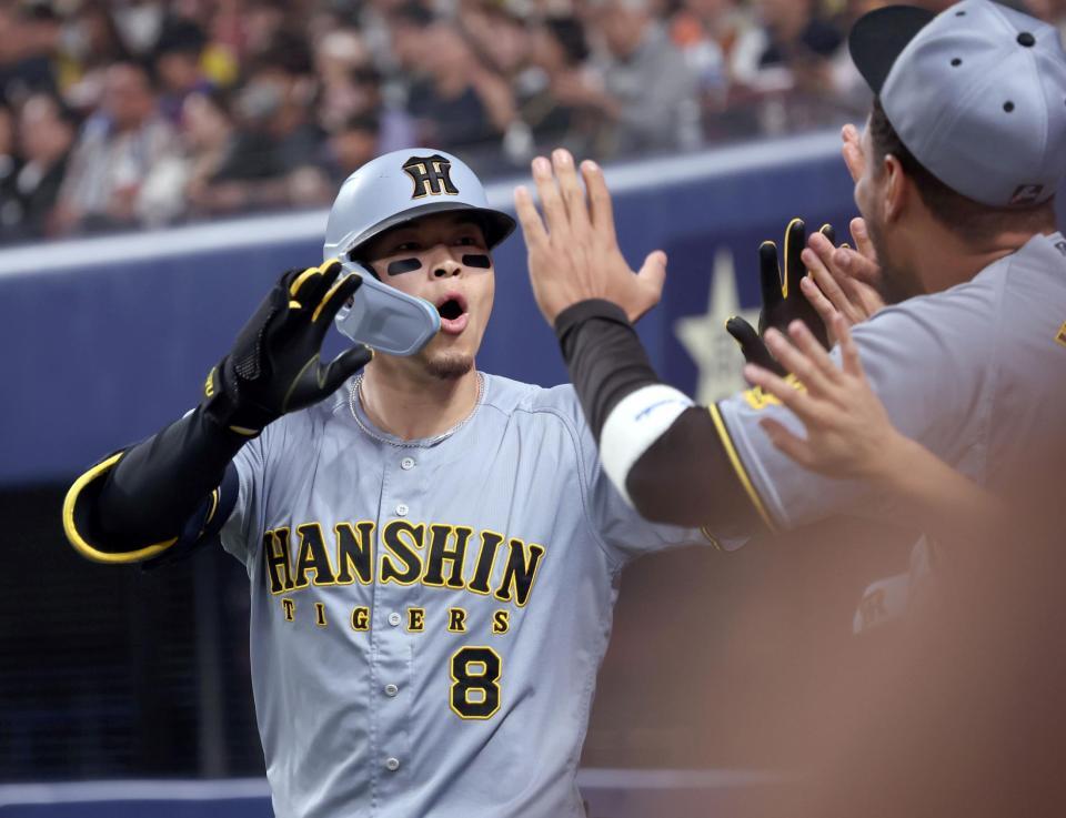 　２回、ソロを放ちナインとタッチを交わす佐藤輝（撮影・田中太一）