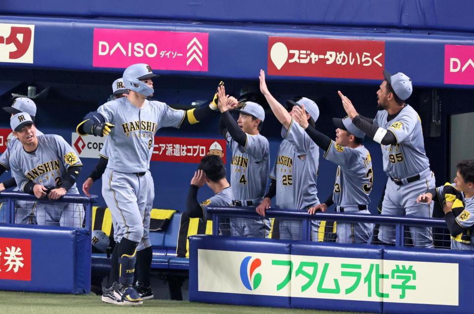 　２回、同点ソロを放ちナインの出迎えを受ける佐藤輝（撮影・立川洋一郎）