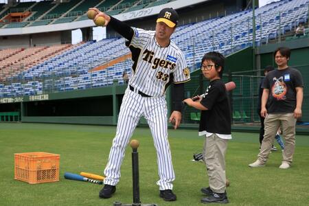 　子どもにアドバイスを送る阪神ＯＢ・葛城氏（球団提供）